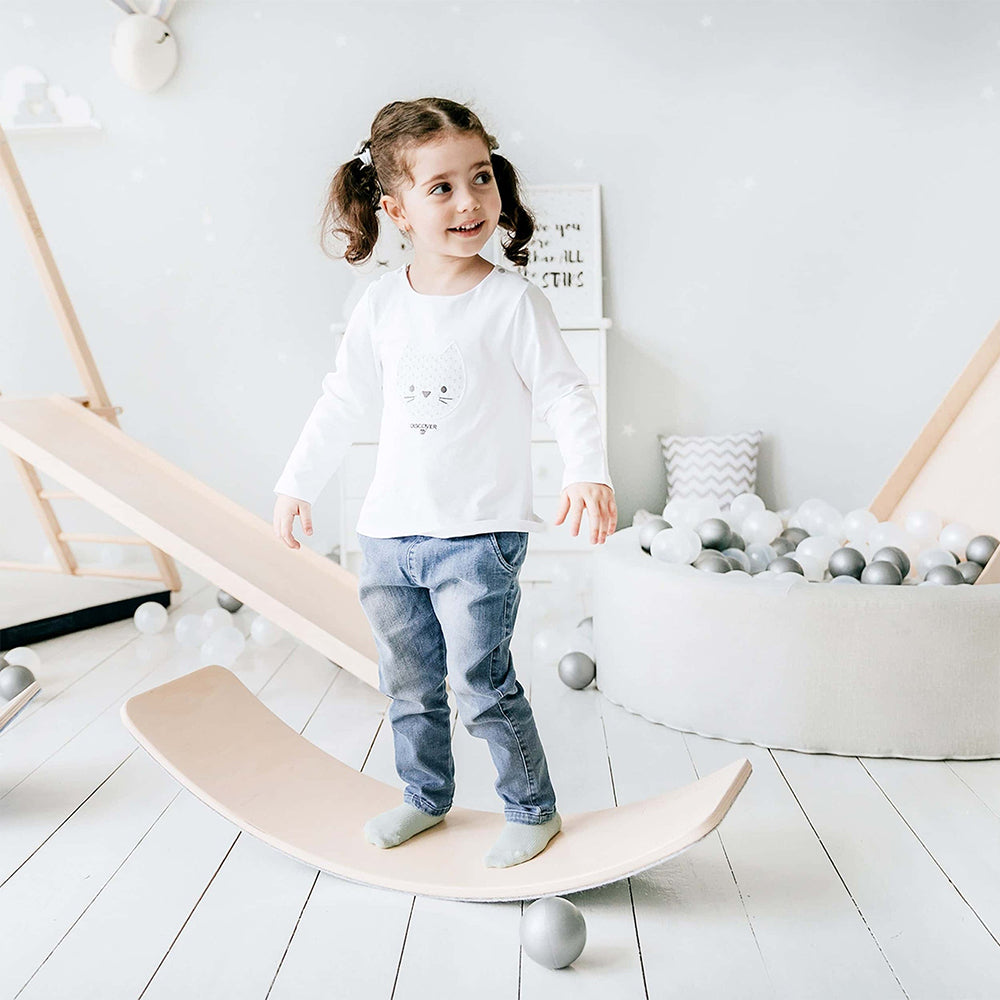 Children standing and balancing on curved wooden balance boards for sensory play