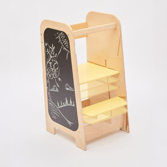 Montessori learning tower made of natural wood with a yellow side busy board, featuring interactive gears, sliders, and lockable elements for toddlers.